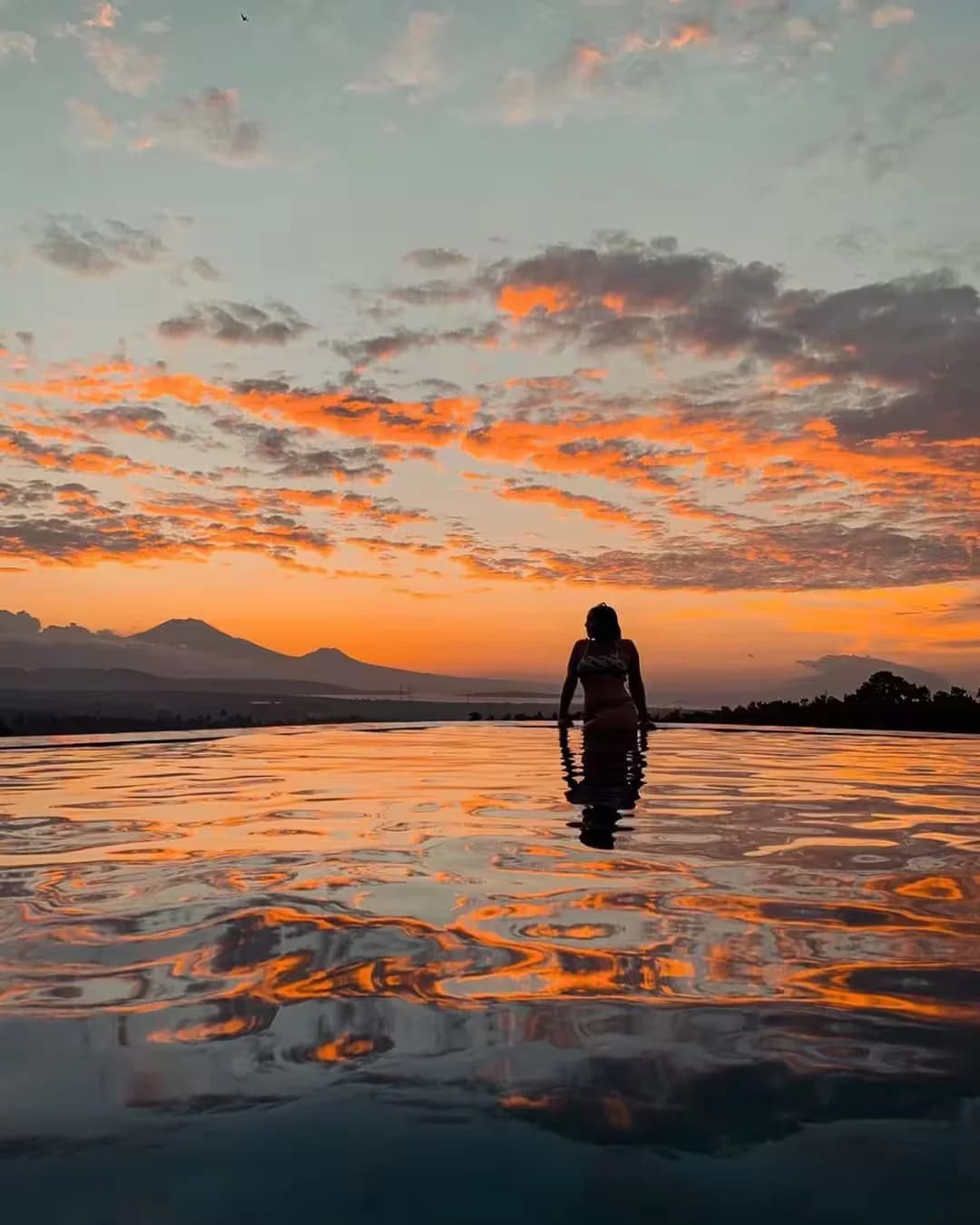 Sunset reflections in Lingga pool with volcanic silhouettes