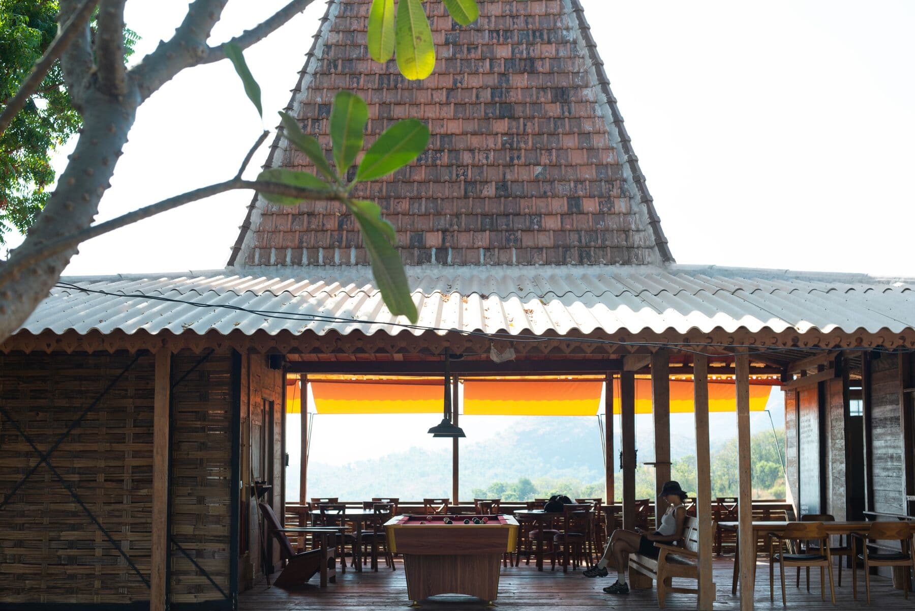 The open-sided Whana Warung building with a tiled roof, tables and a pool table inside