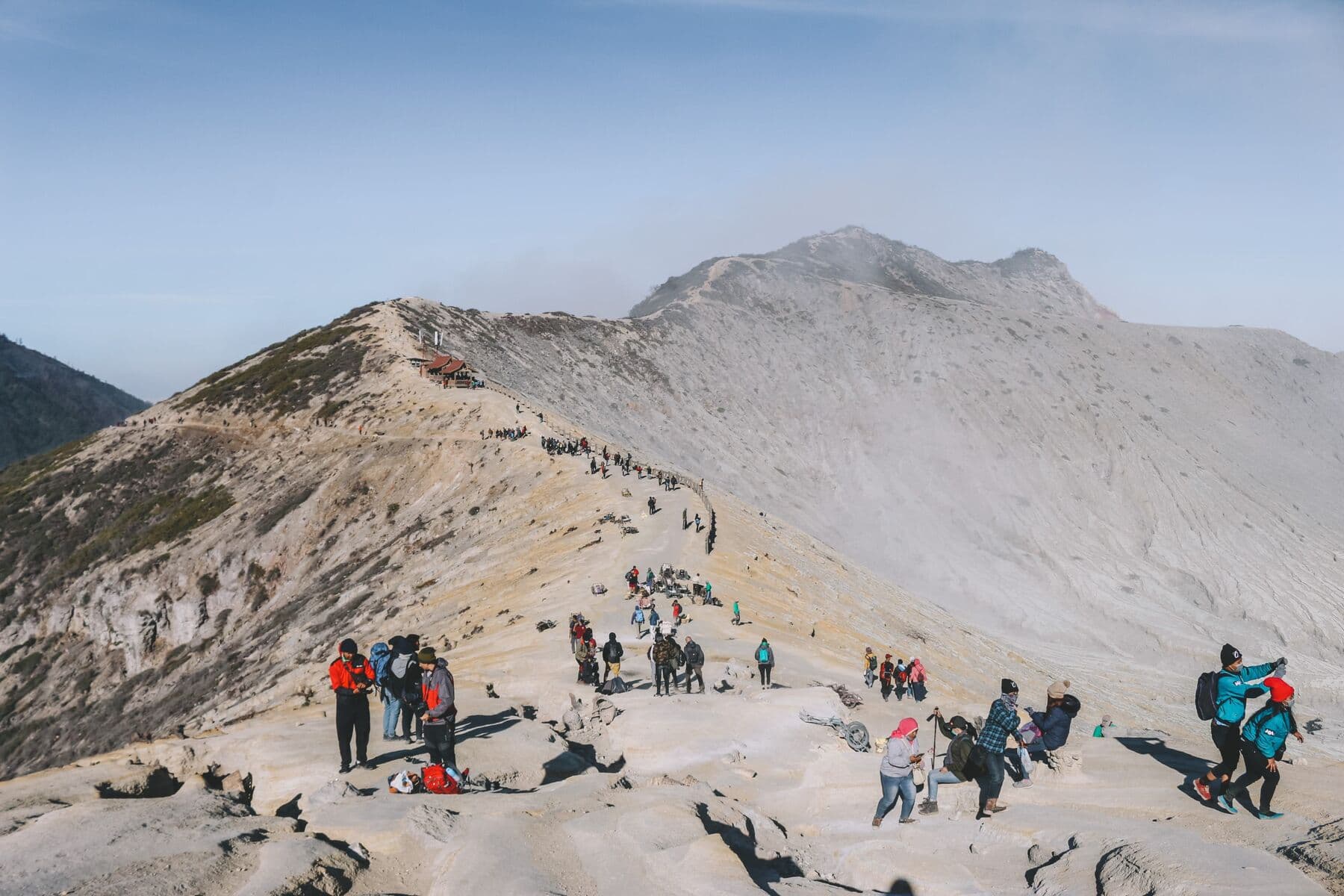 Hikers on the crater rim trail of Ijen with the volcano peak behind