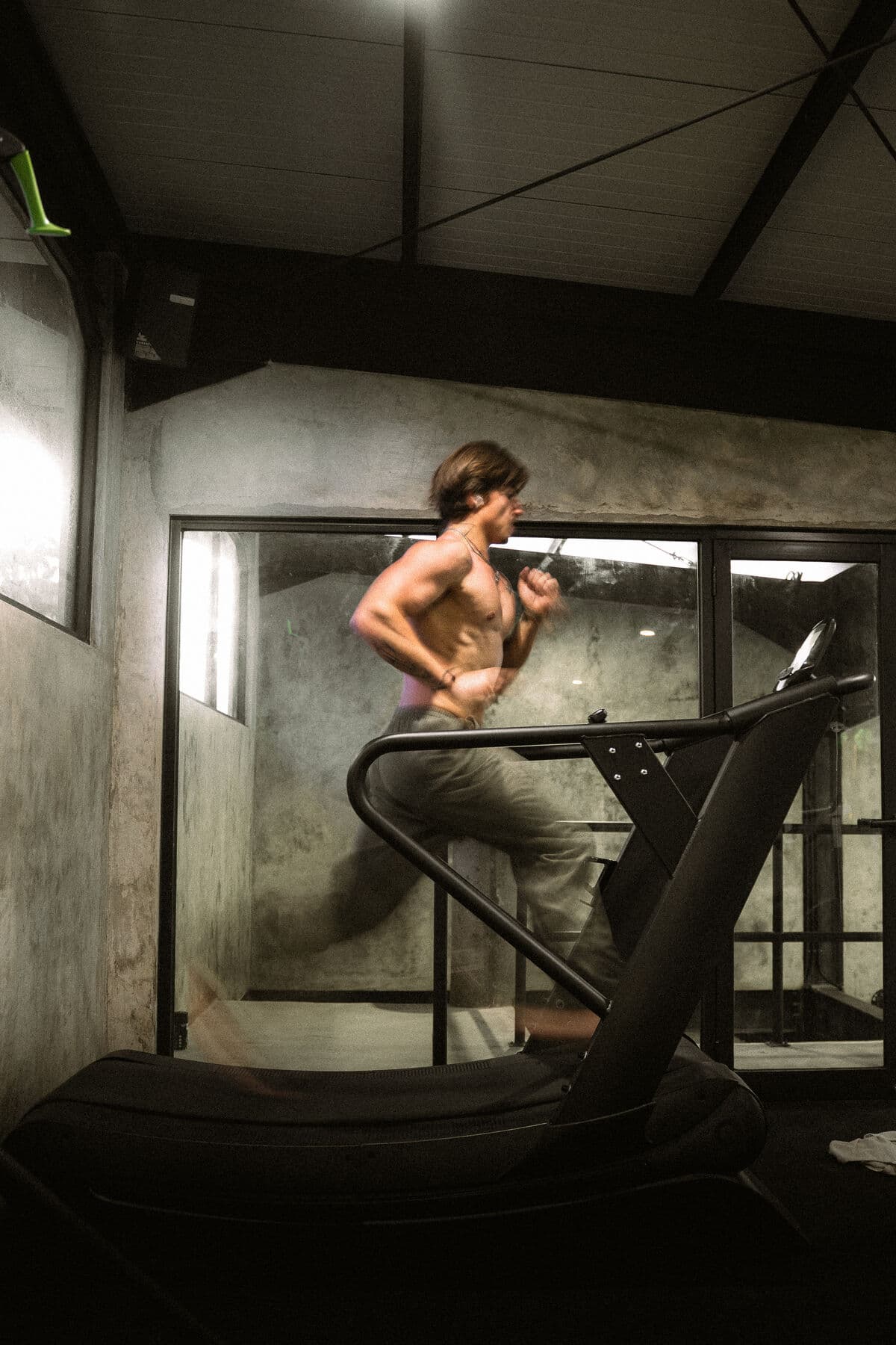 A man running on a curved treadmill in a gym