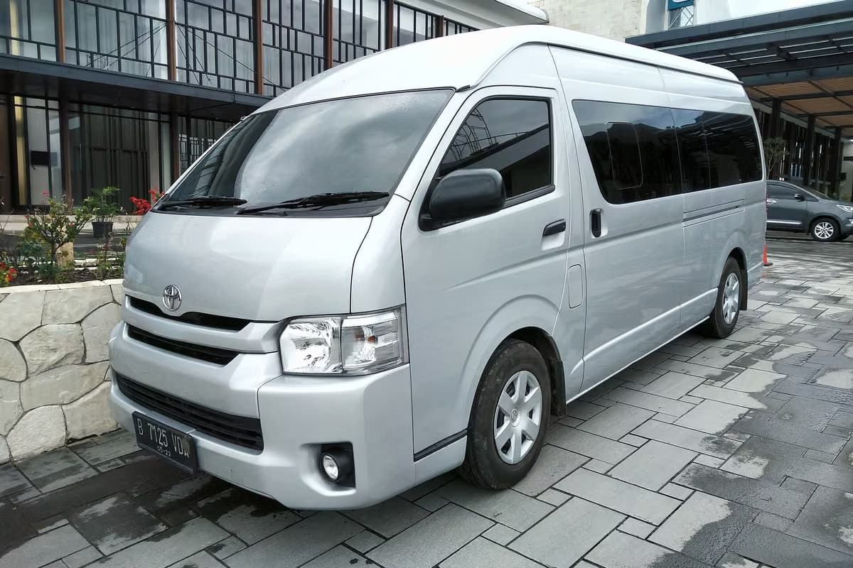 A silver Toyota Hiace minibus with a high roof