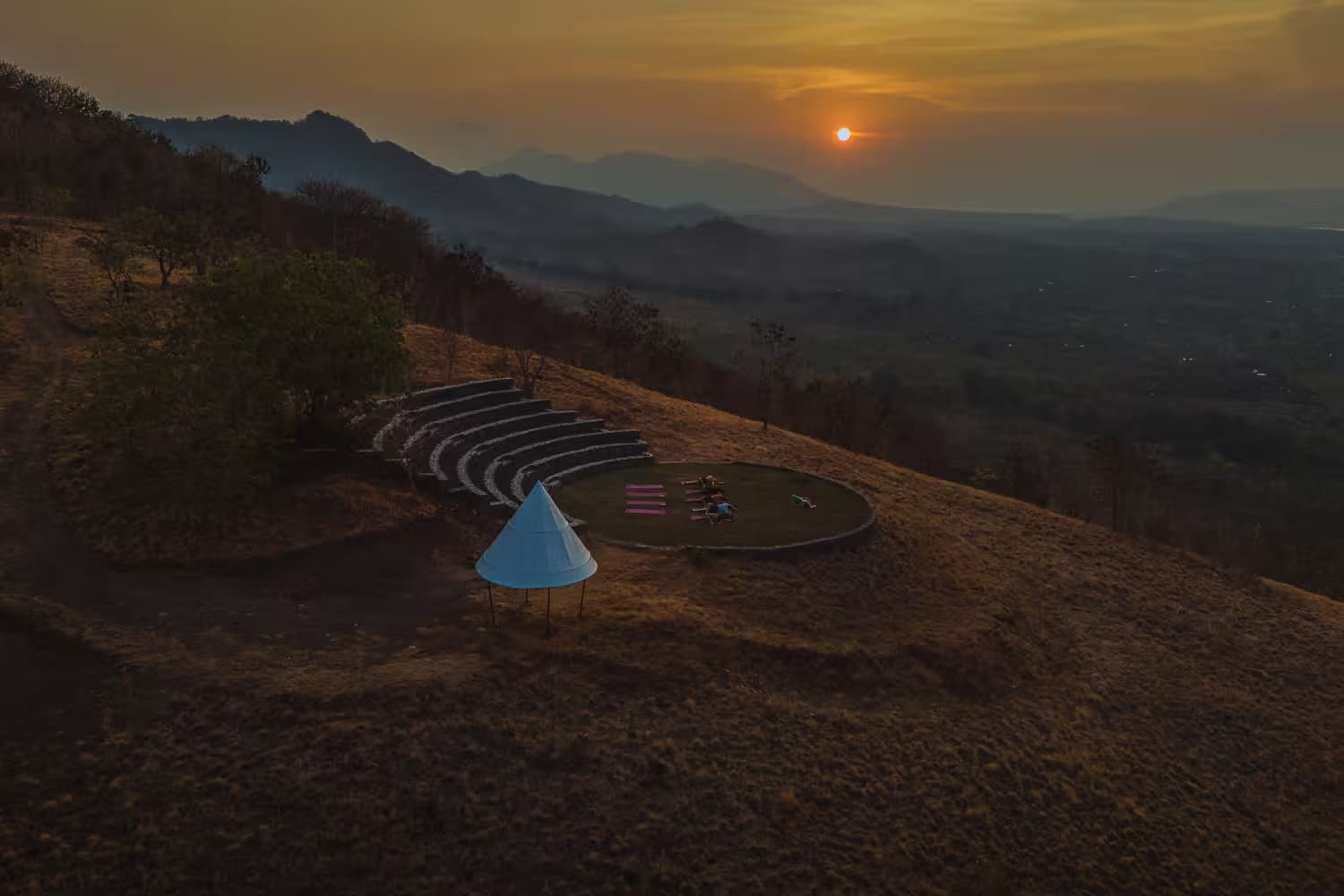 Sunset yoga session at the stage with dramatic sky and panoramic views