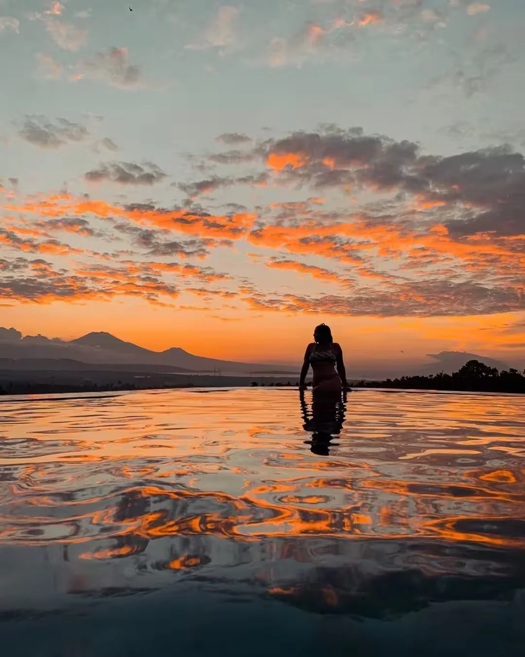 Sunset reflections in Lingga pool with volcanic silhouettes