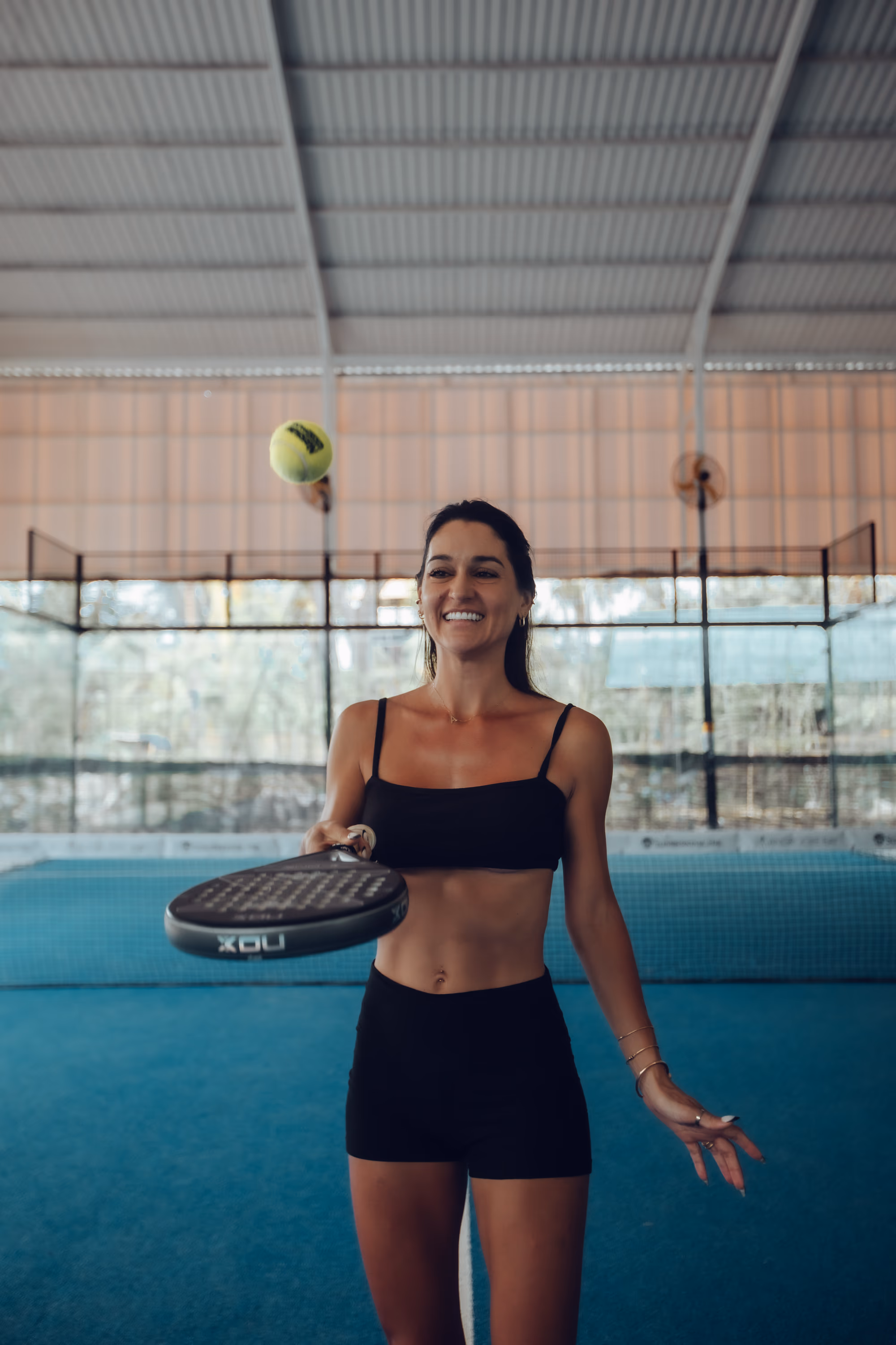Padel player bouncing ball on racket