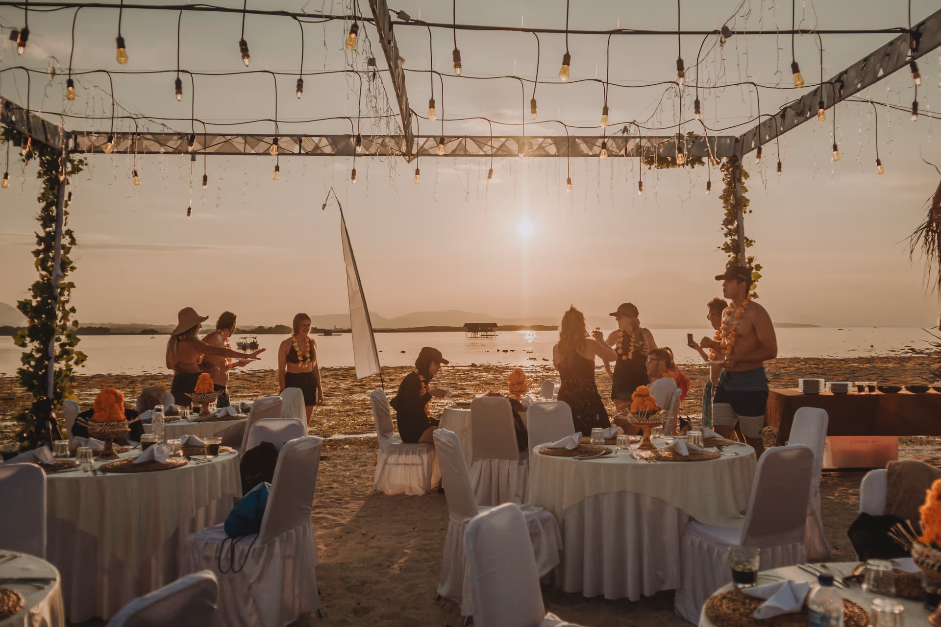 Group dining celebration setup on pristine Gilih Putih Island beach