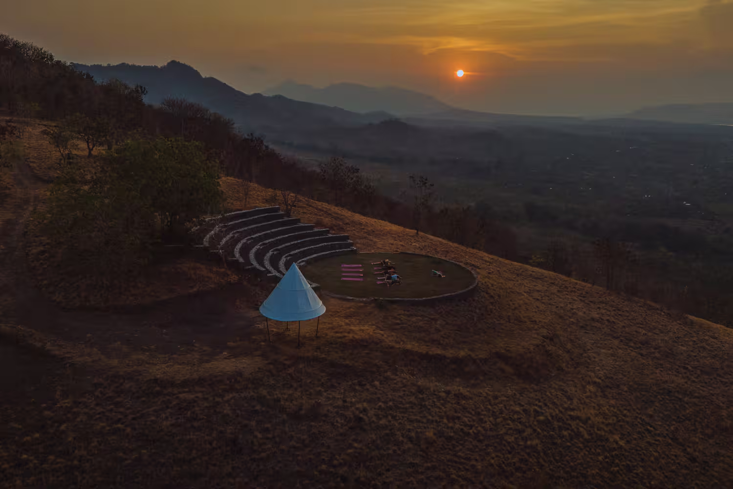 Sunset yoga session at the stage with dramatic sky and panoramic views